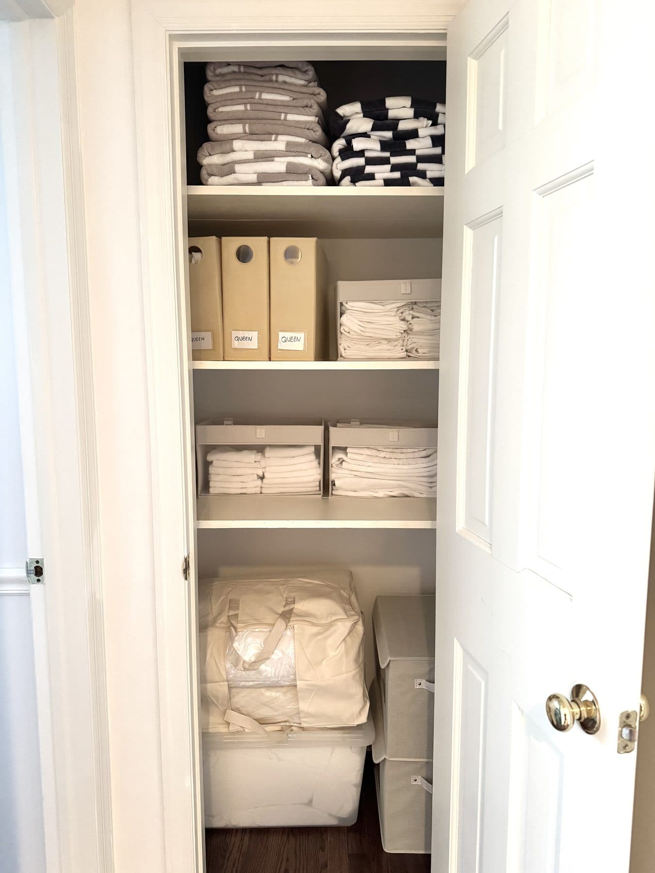 Neatly folded linens and labeled boxes in an organized closet