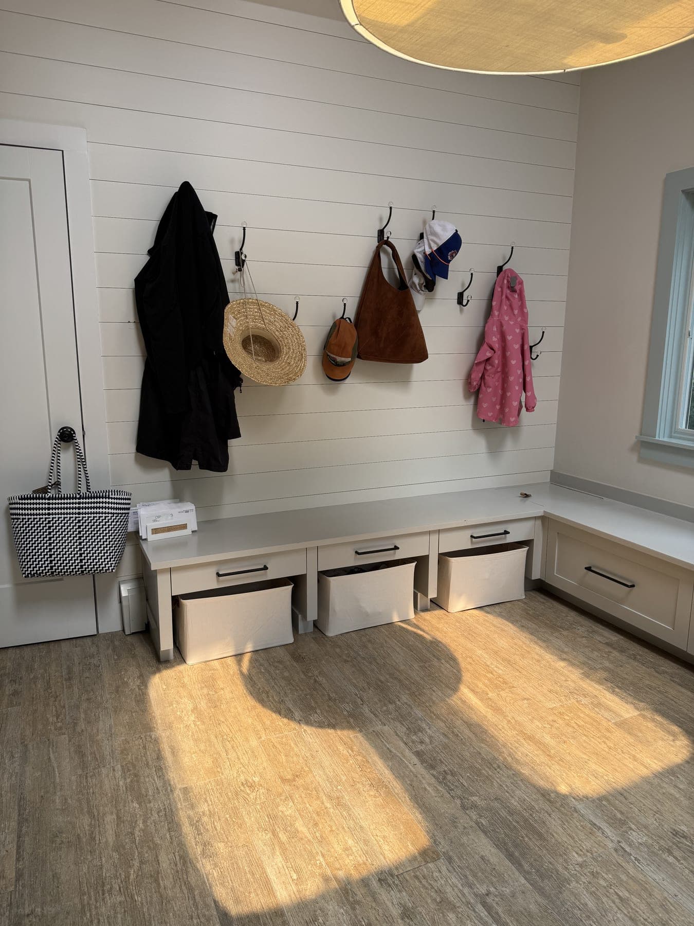 Bright, tidy mudroom with clear bench and baskets after an IZEN session