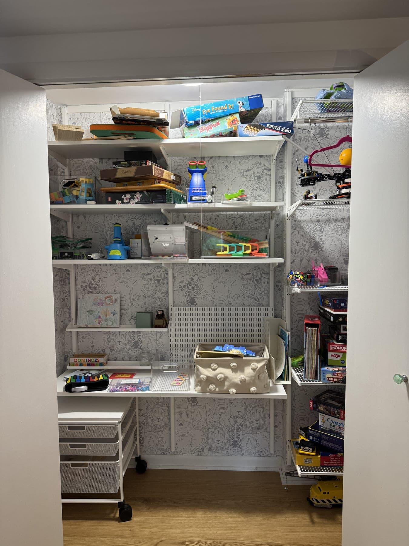Toy closet shelves crowded with games and boxes before organization